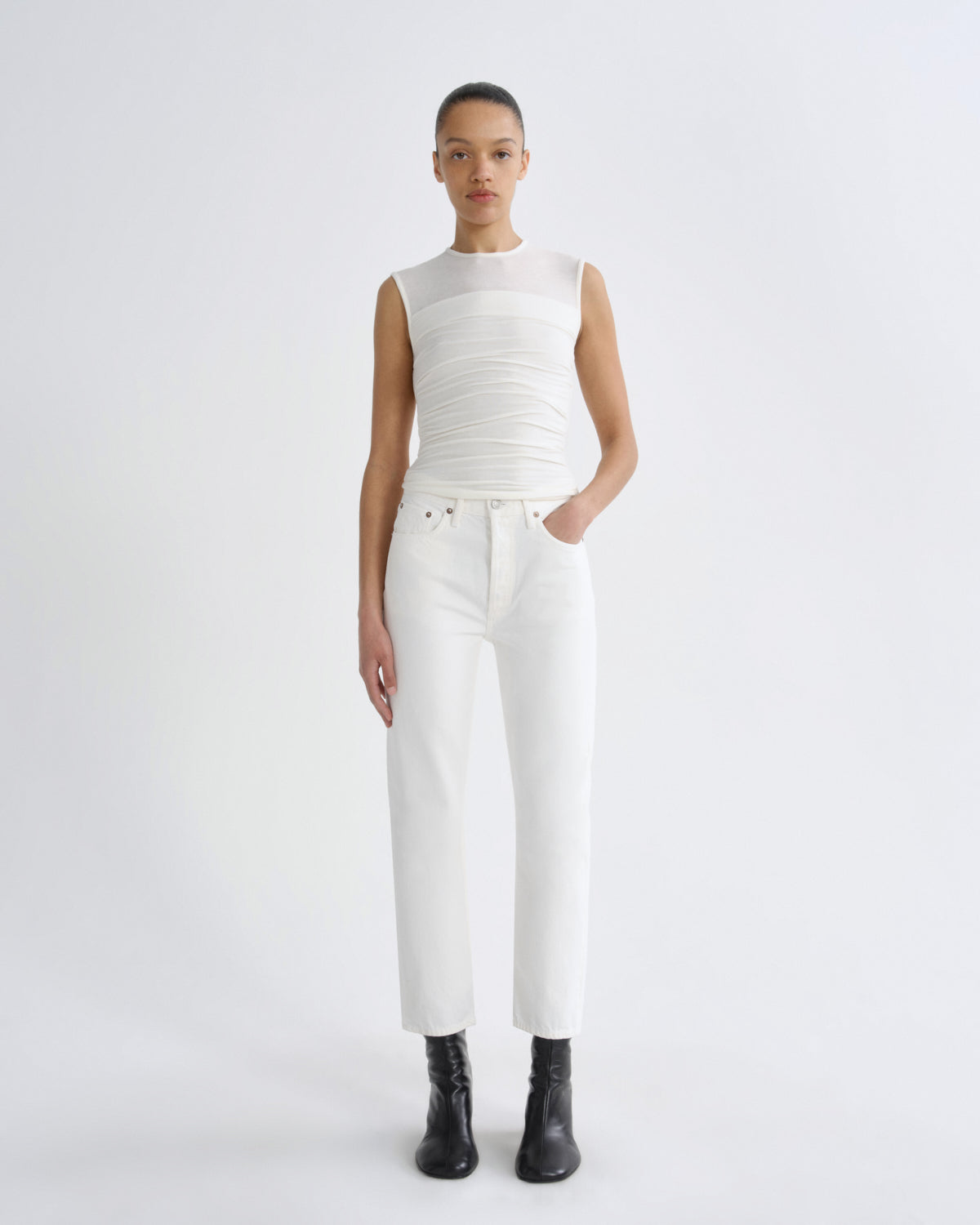 Person wearing a white sleeveless top and pants on a white background