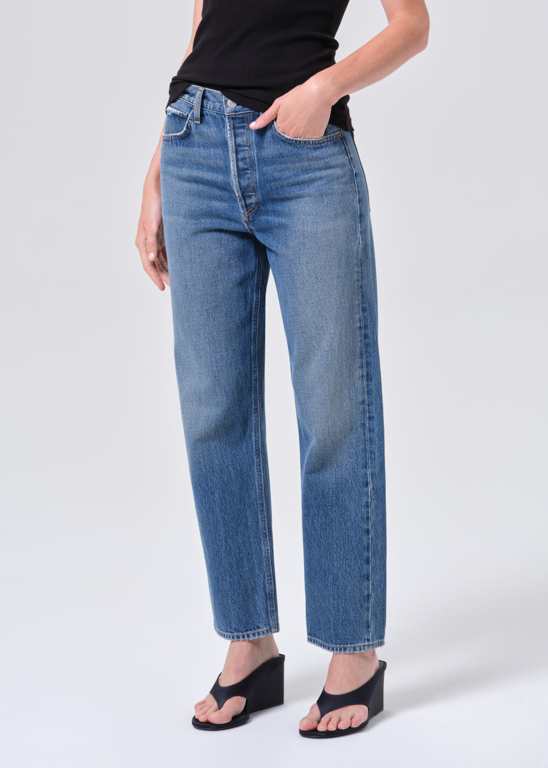 Person wearing blue jeans on a white background