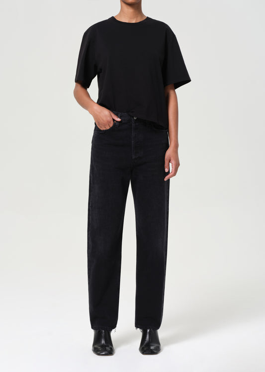 Person wearing a black t-shirt and black pants on a white background