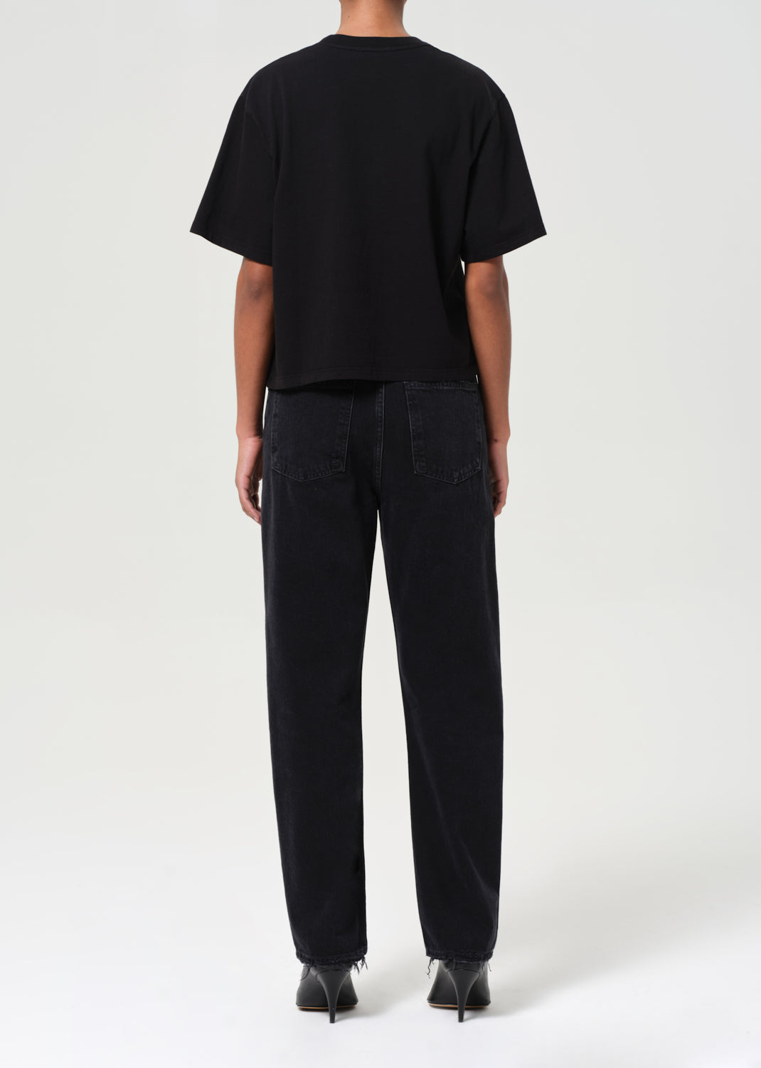 Person wearing a black t-shirt and black pants on a white background