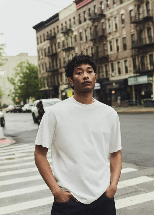 Man wearing a white t-shirt on a city street