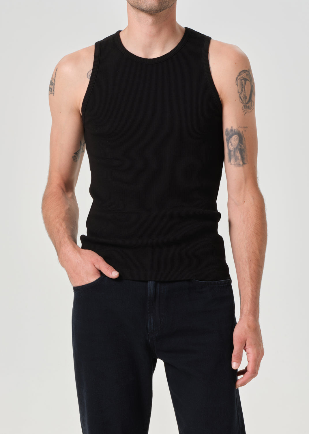 Person wearing a black sleeveless shirt and black pants on a plain background