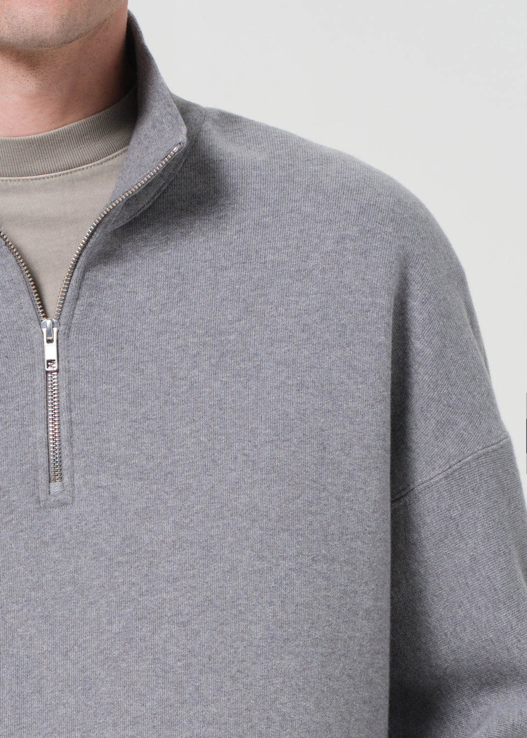 Gray pullover with a quarter zip on a neutral background