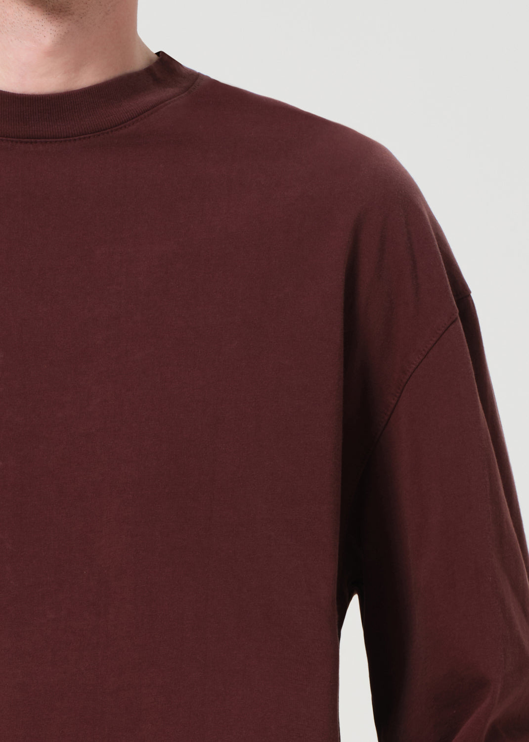 Close-up of a maroon sweatshirt on a plain background