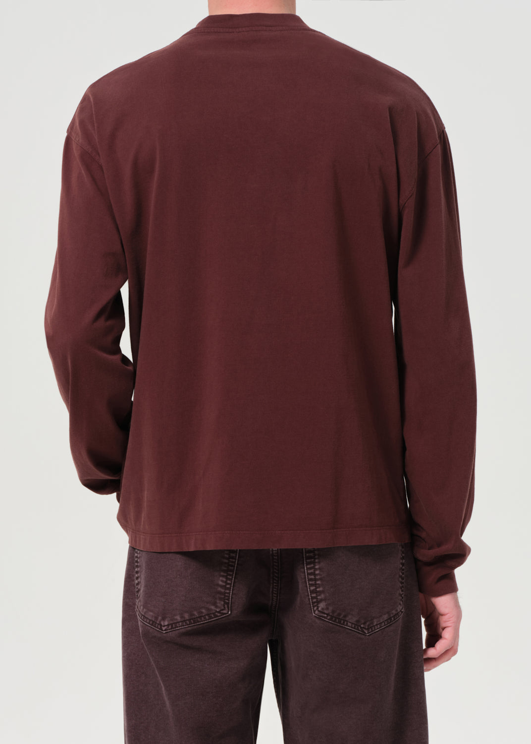 Brown long-sleeve shirt worn by a person on a white background