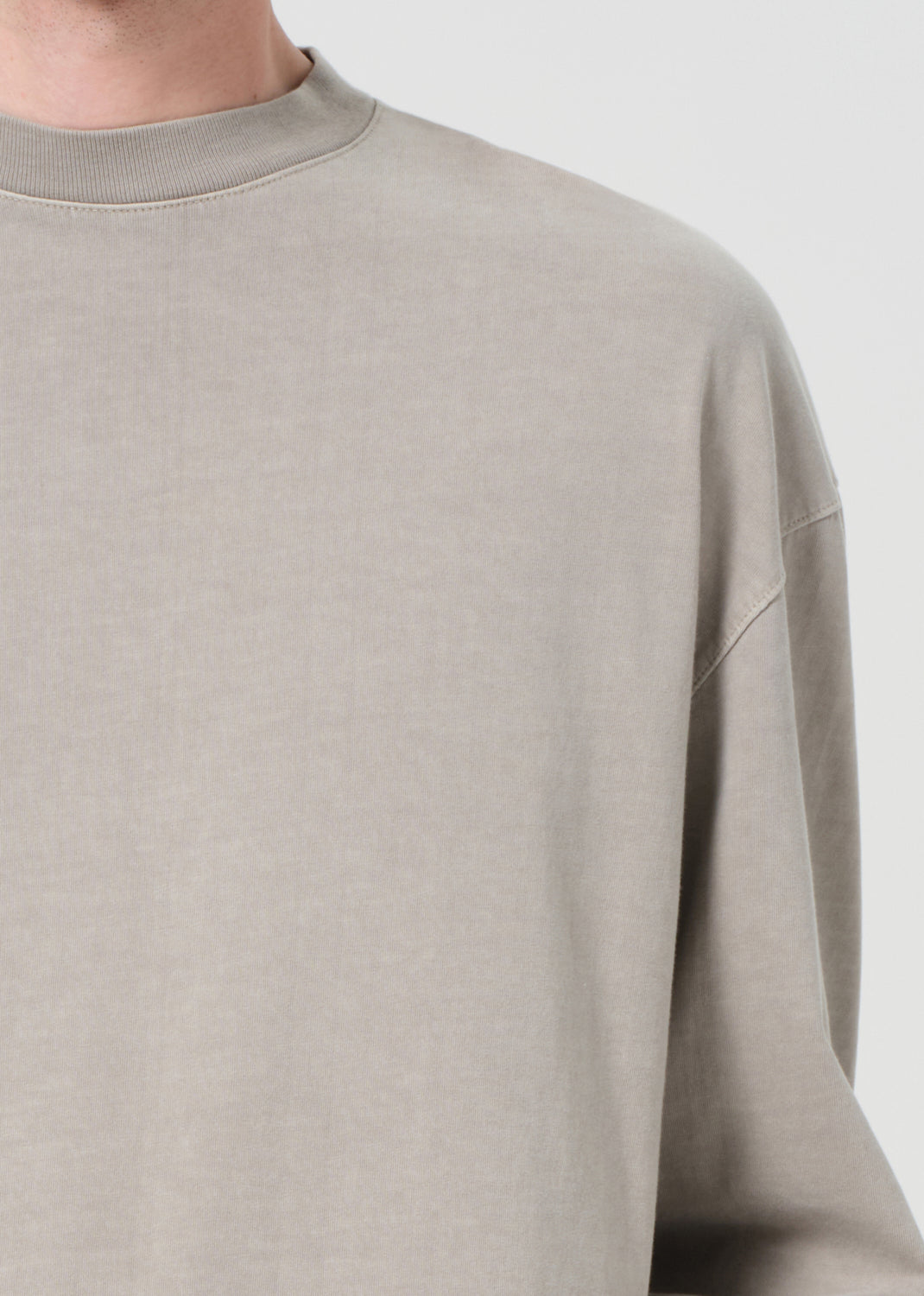 Beige sweatshirt worn by a person on a plain background