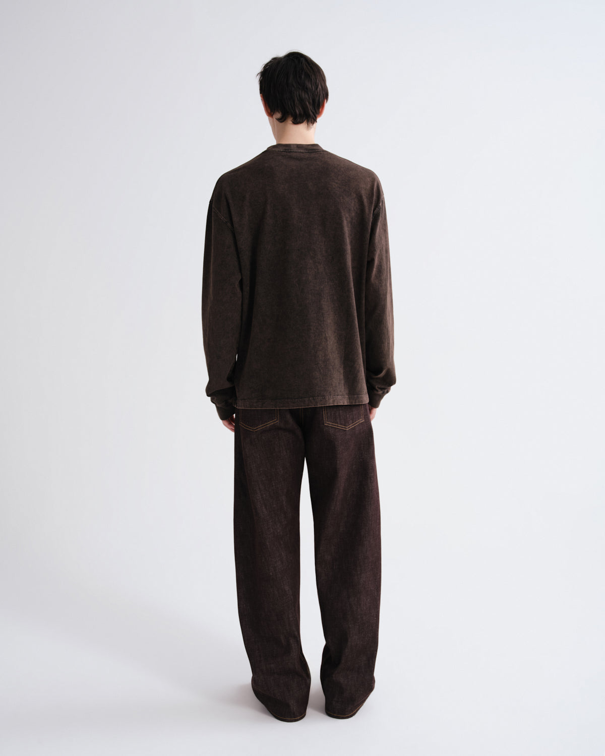 Person wearing a brown outfit on a white background