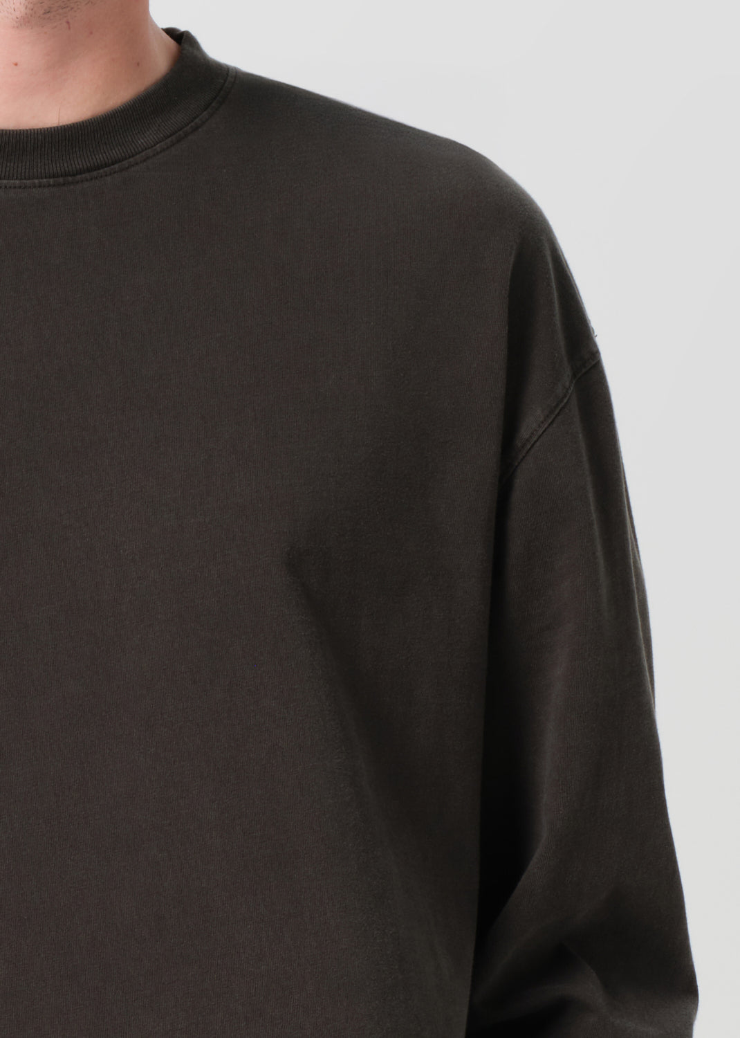 Black sweatshirt worn by a person on a light gray background
