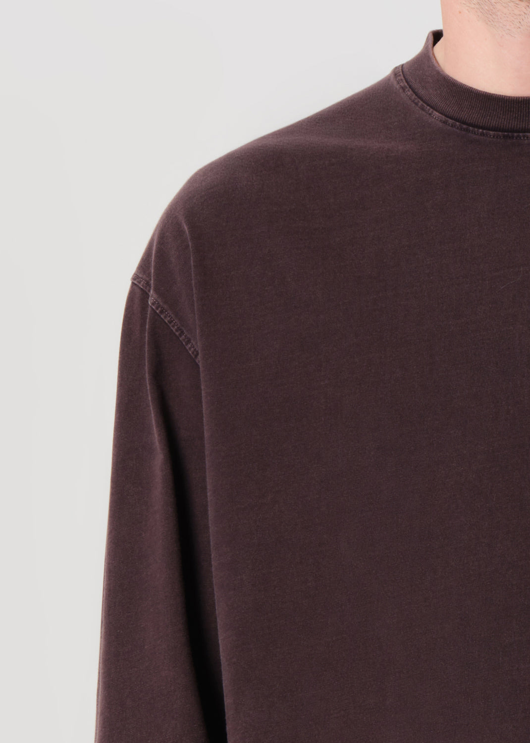 Close-up of a dark brown sweatshirt on a light gray background
