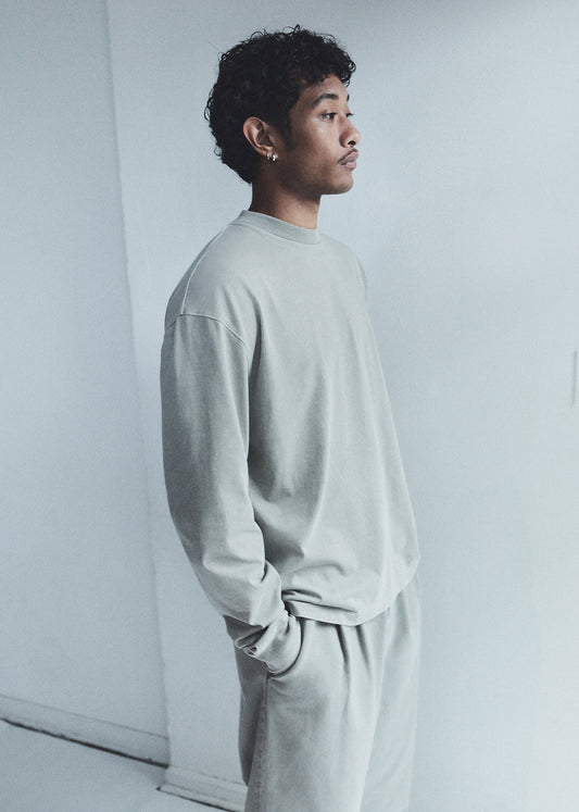 Person wearing a light gray outfit against a white background
