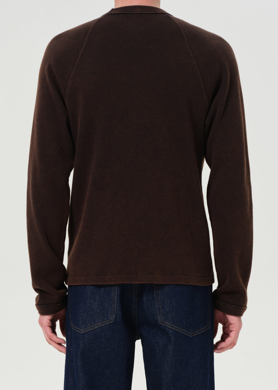 Brown long-sleeve shirt worn by a person on a white background