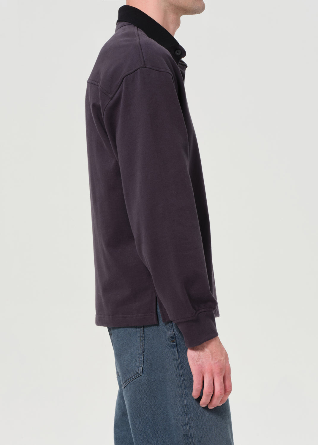 Dark jacket worn by a person on a light gray background