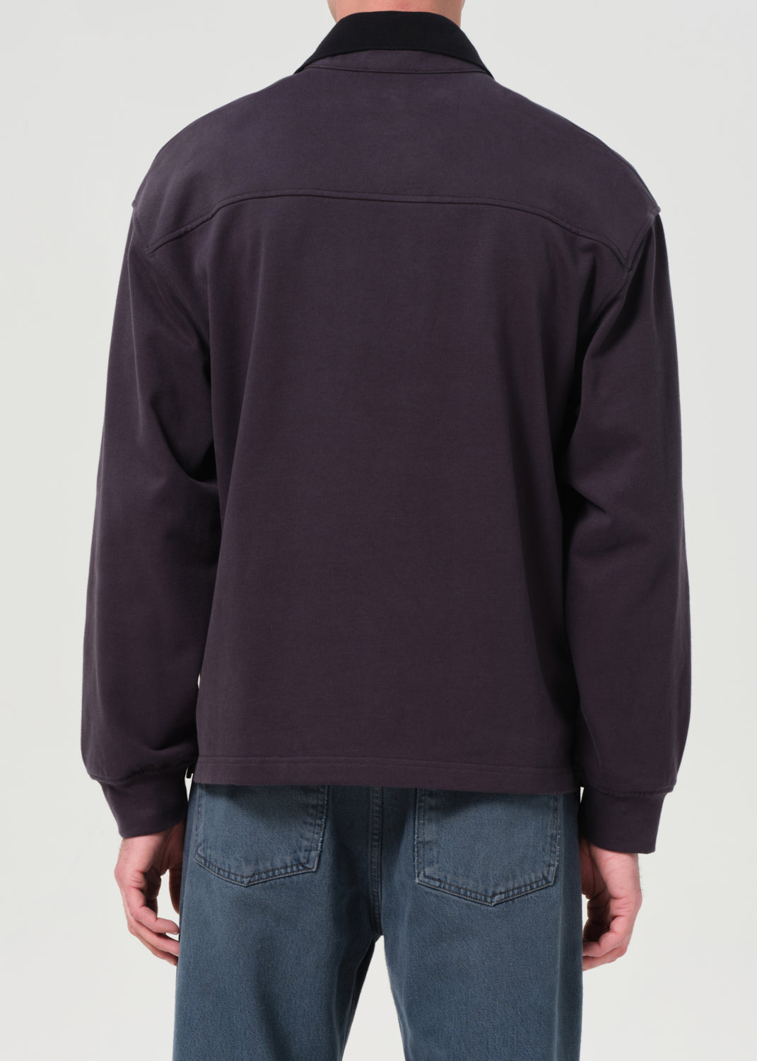 Dark jacket worn by a person on a light gray background