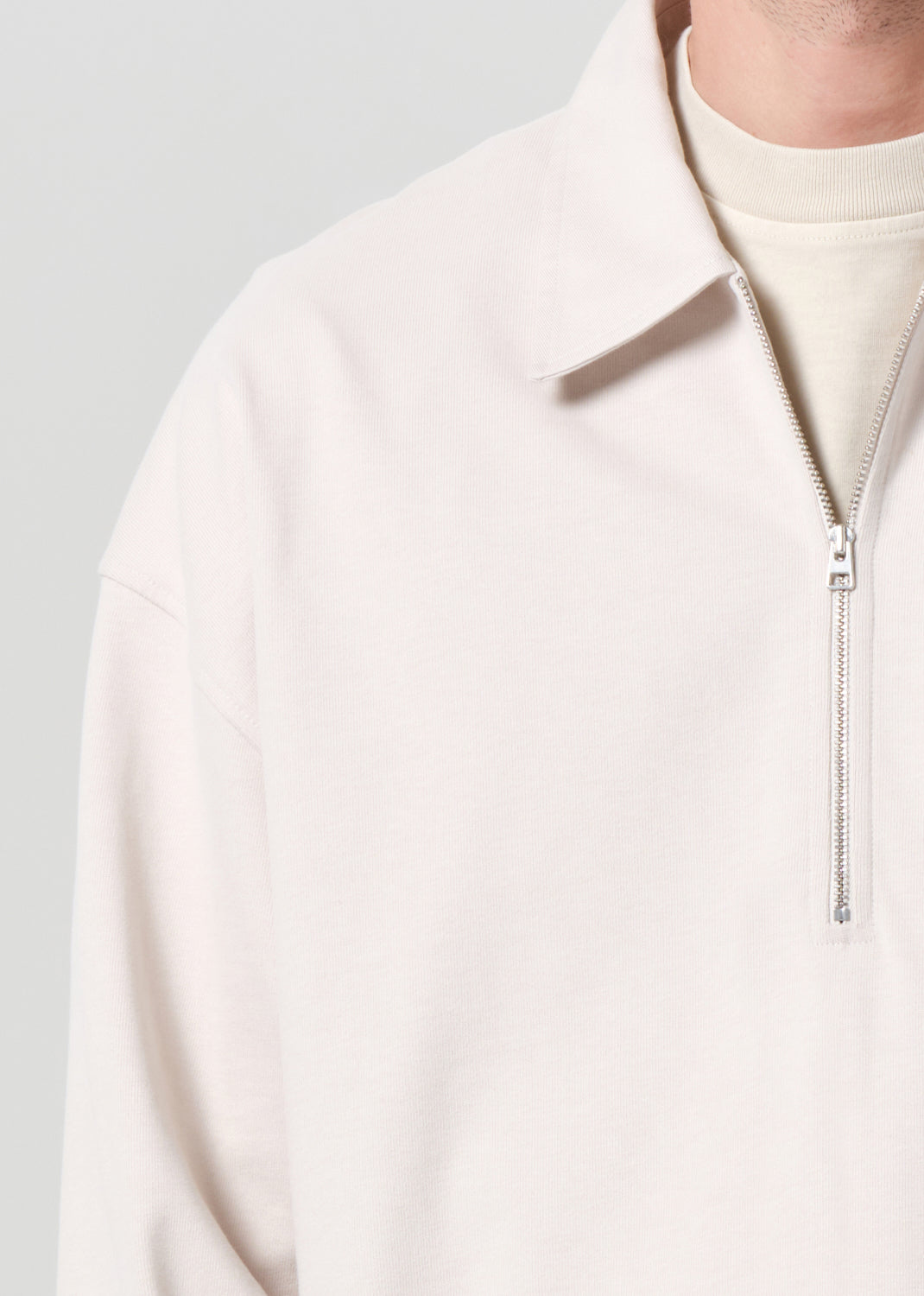 Close-up of a light pink fleece jacket with a zipper on a gray background