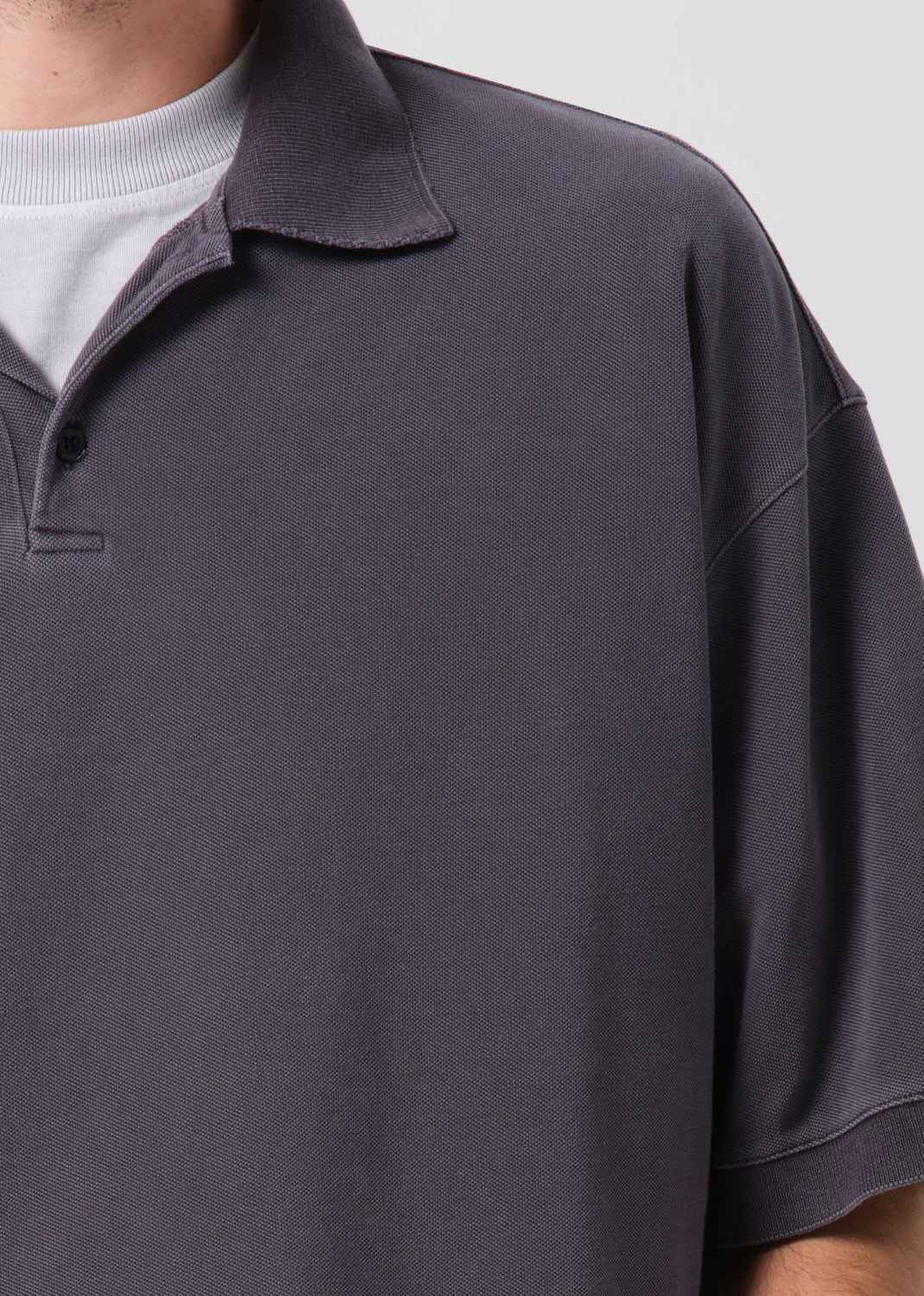 Close-up of a dark gray polo shirt with a white collar.