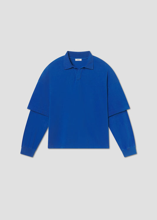 Flat lay shot of blue long-sleeve shirt on a grey background