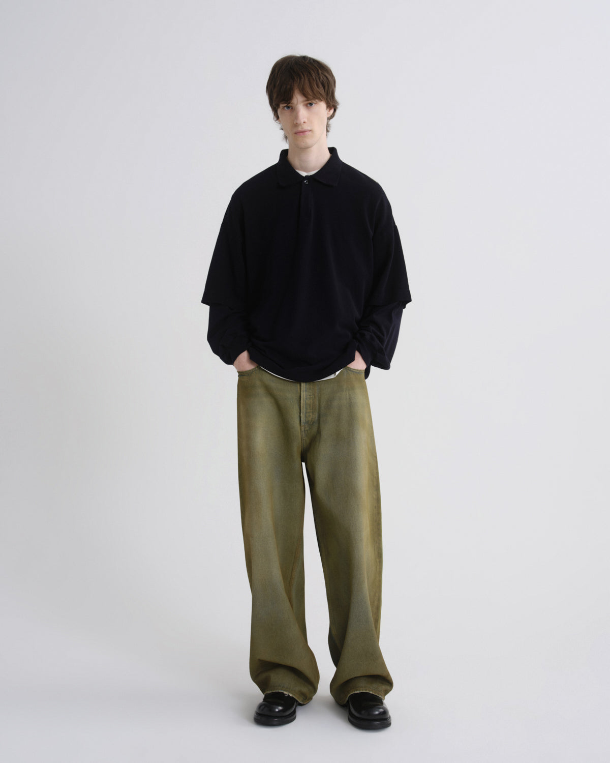 Person wearing a black shirt and green pants on a white background