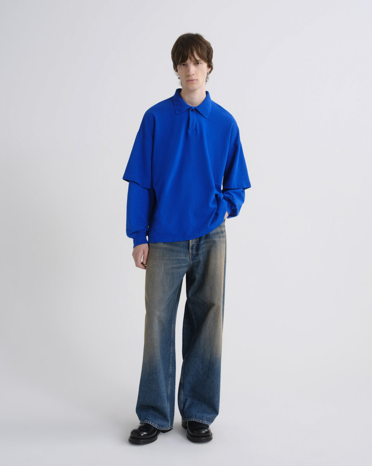 Person wearing a blue sweater and jeans on a white background