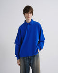 Person wearing a bright blue sweater against a plain background