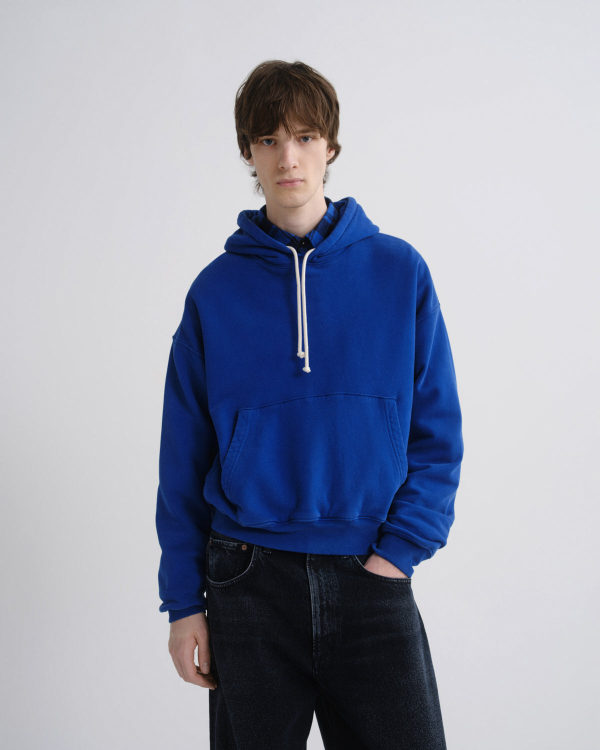 Person wearing a blue hoodie on a plain background