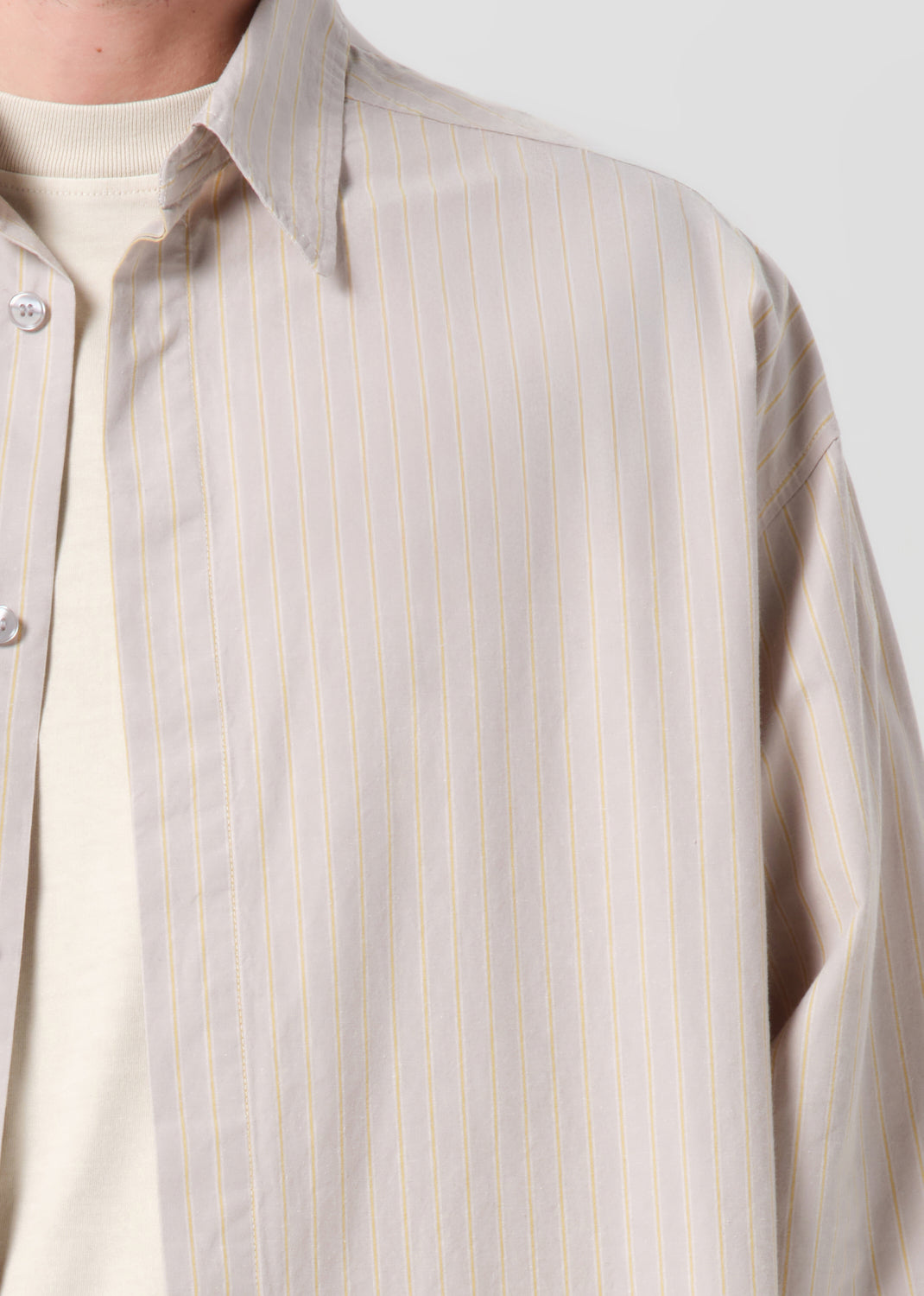 Close-up of a beige striped shirt with a plain background