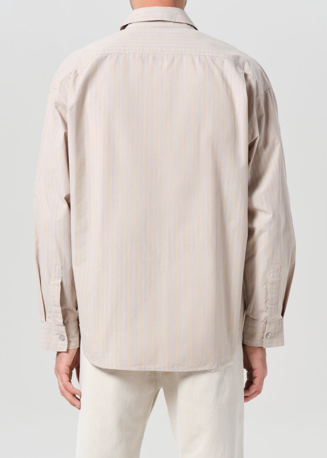 Beige shirt worn by a person on a plain background