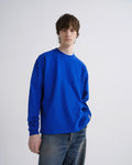 Person wearing a blue sweatshirt against a grey background