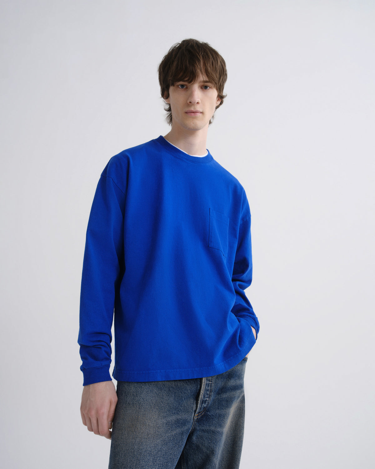 Person wearing a blue sweatshirt against a grey background
