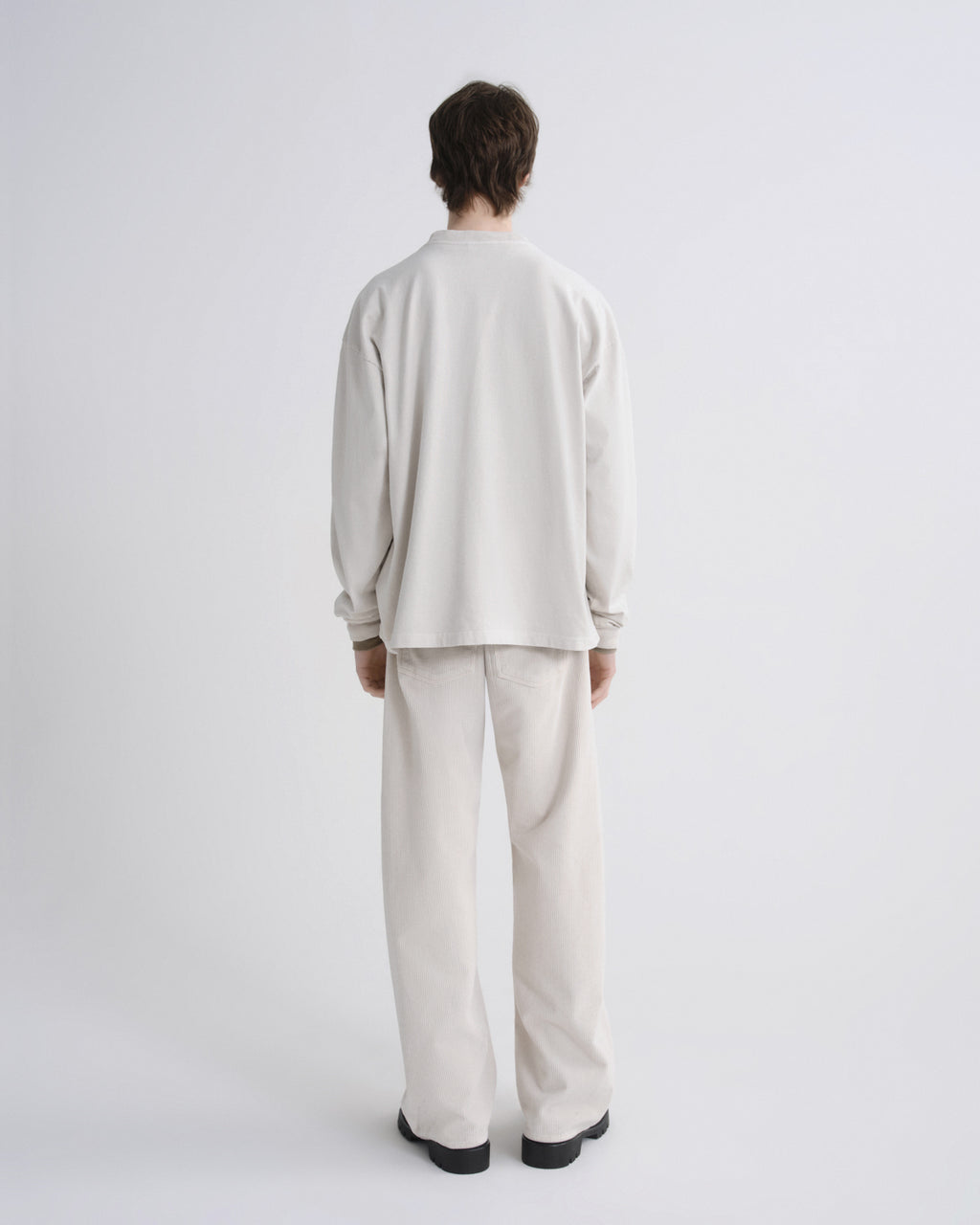 Person wearing a beige outfit on a white background