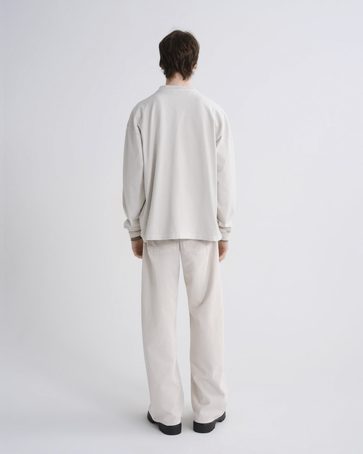 Person wearing a beige outfit on a white background