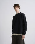 Person wearing a black sweater and brown pants on a white background