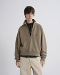 Person wearing a beige half-zip sweatshirt on a white background