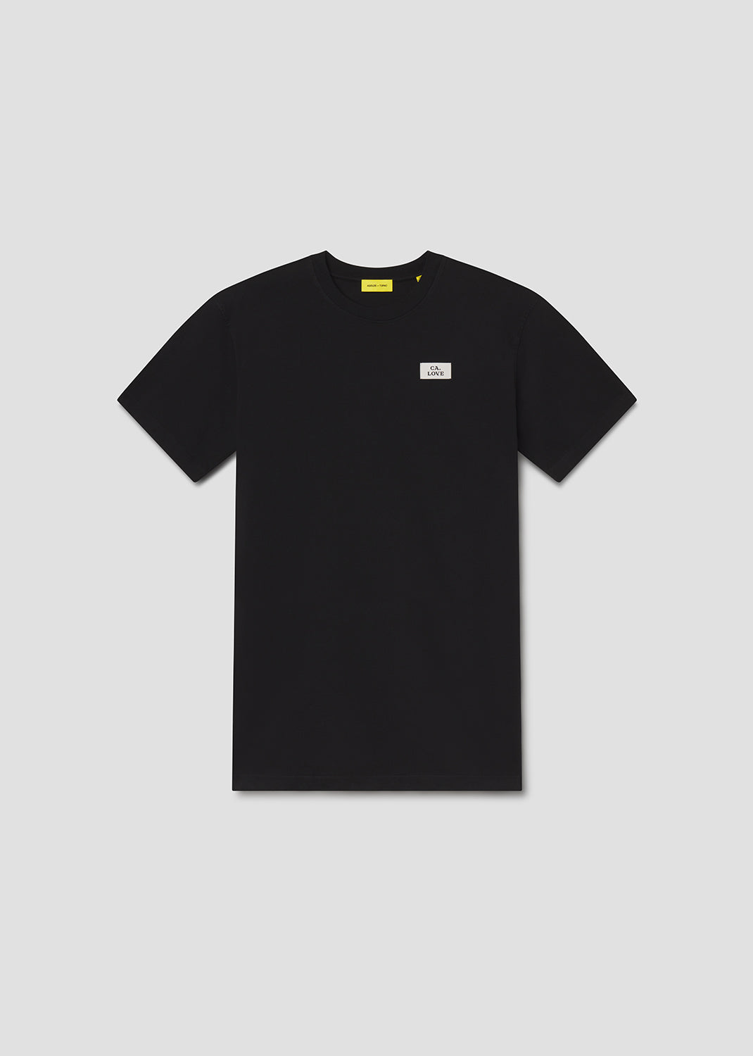 Black t-shirt with a small white logo on a light gray background