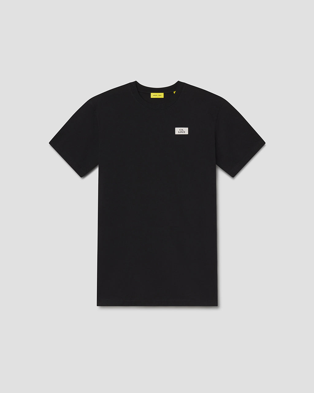 A black short-sleeve crewneck t-shirt with a small white rectangular logo patch on the left chest and a yellow neck label, displayed flat against a light gray background.