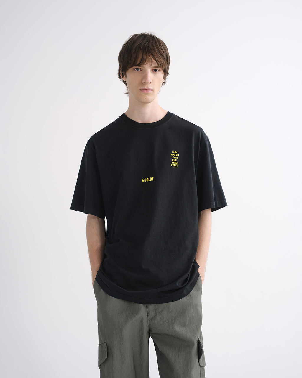Person wearing black graphic T-shirt and grey cargo pants, front view