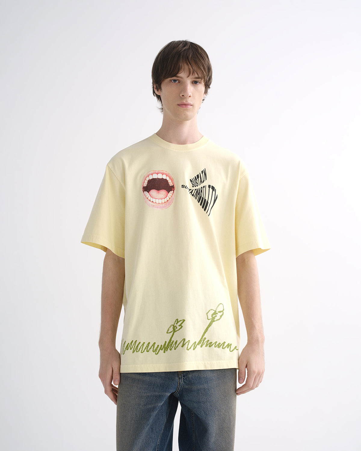 Person wearing pale yellow graphic T-shirt and blue jeans, front view