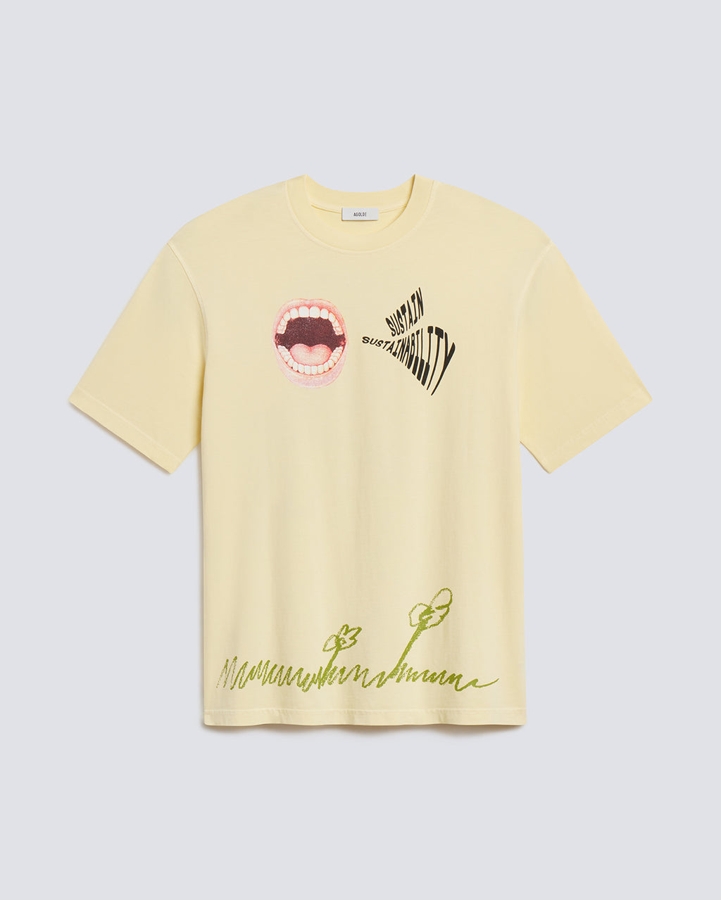 A pale yellow short-sleeve t-shirt with graphic prints, featuring a mouth graphic and the word 'MUTUAL' on the chest, and green script text near the hem, displayed on a light gray background.