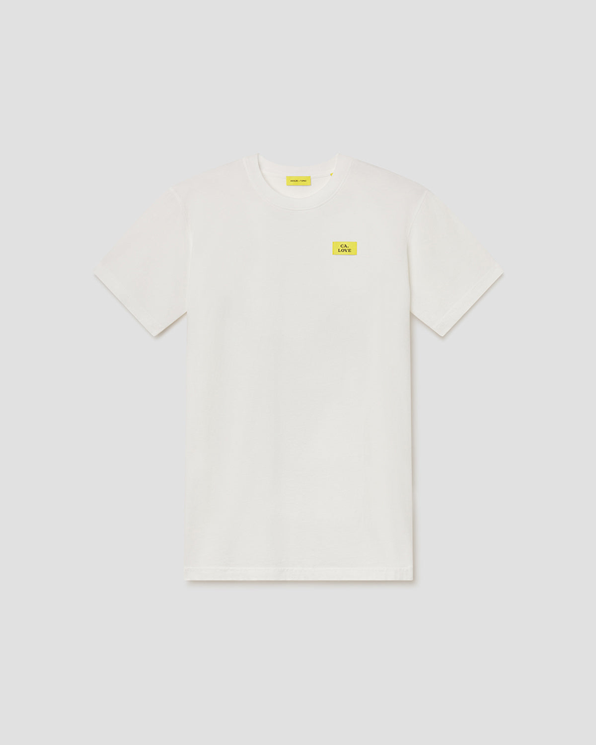 An off-white short-sleeve crewneck t-shirt with a small yellow rectangular logo patch on the left chest, displayed flat against a light gray background.