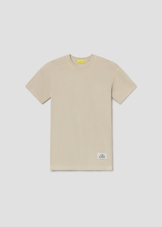 Beige t-shirt with a small label on a light gray background