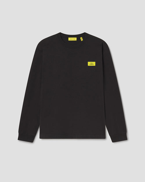 A black long-sleeve crewneck sweatshirt with a small yellow rectangular logo patch on the left chest, displayed on a neutral light gray background.