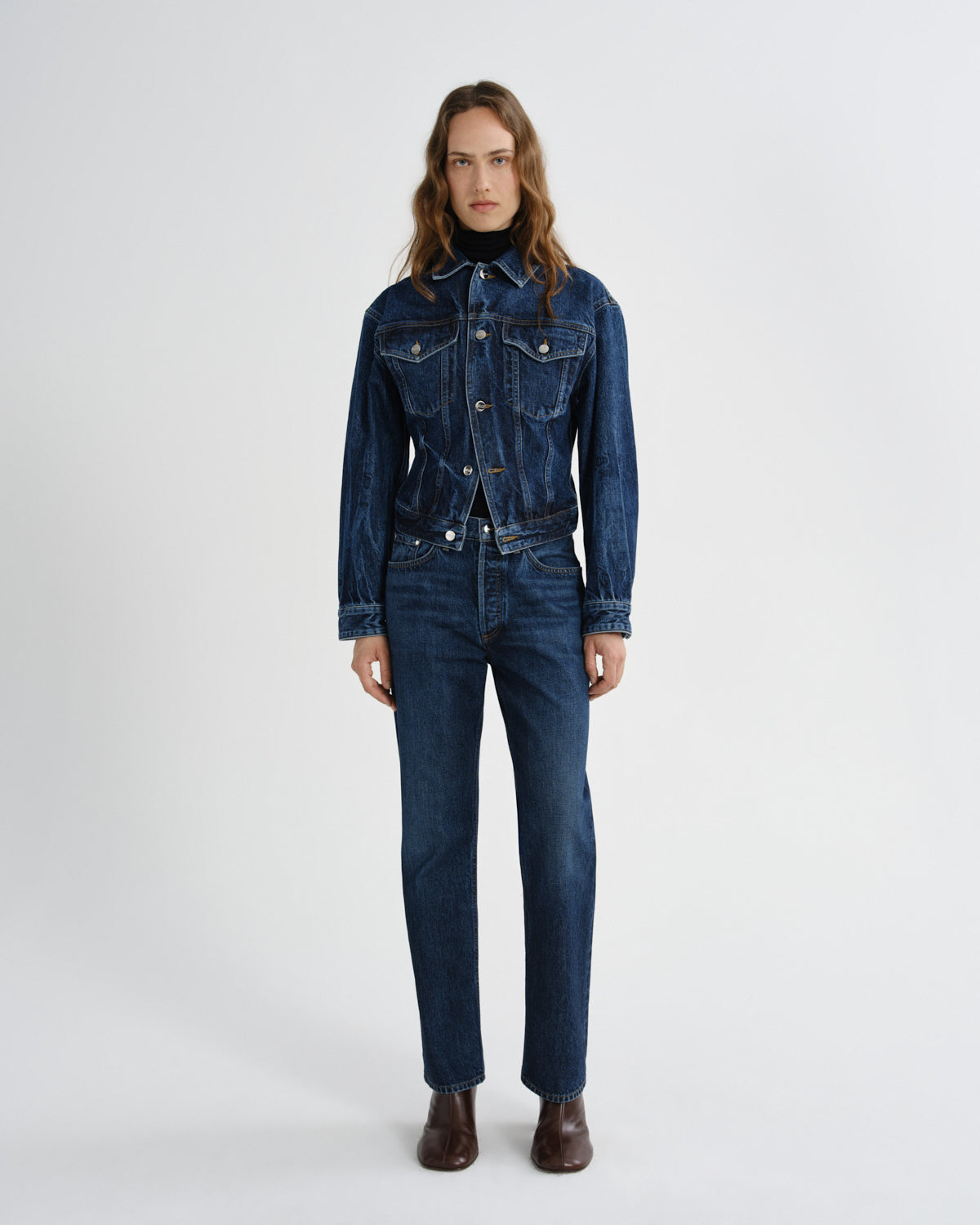 Person wearing a blue denim outfit on a white background