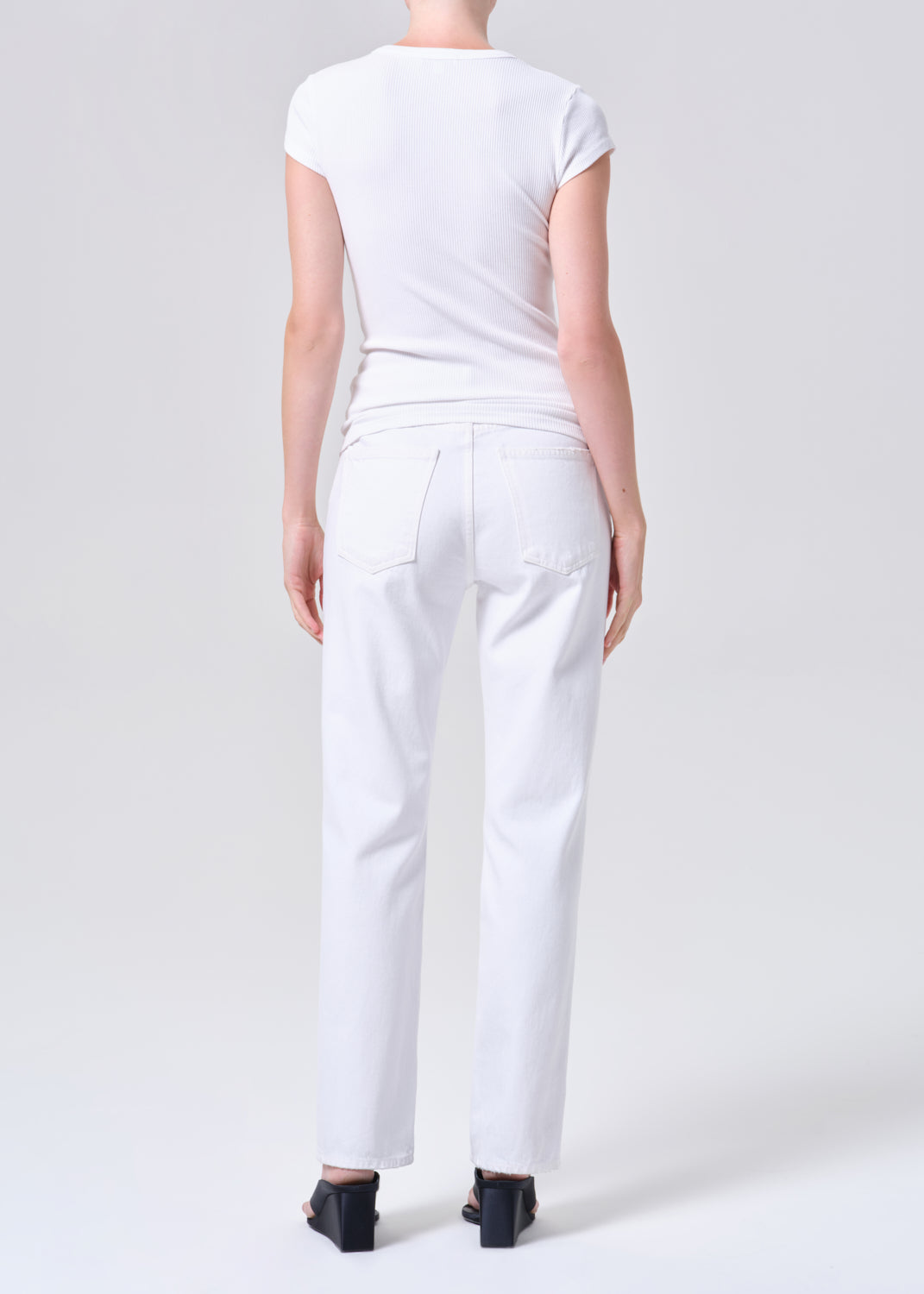 Person wearing a white outfit on a plain background