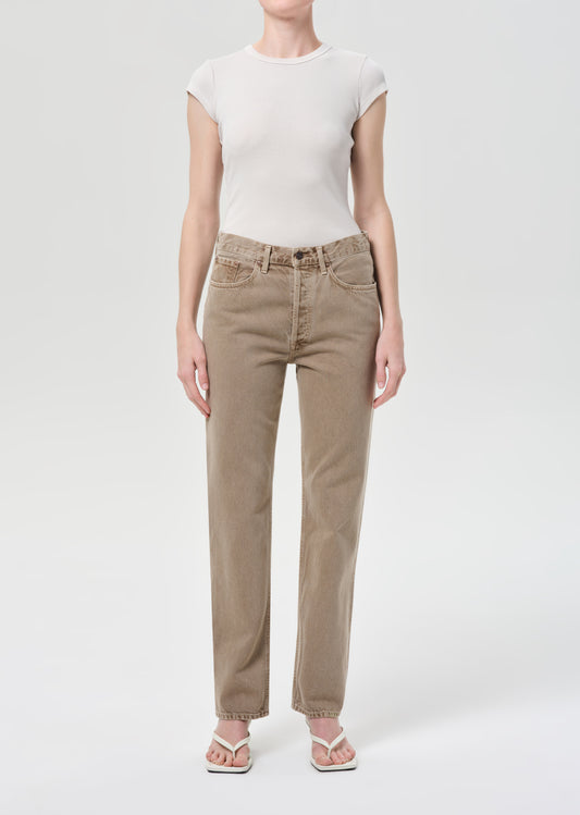Person wearing beige pants and a white top on a white background