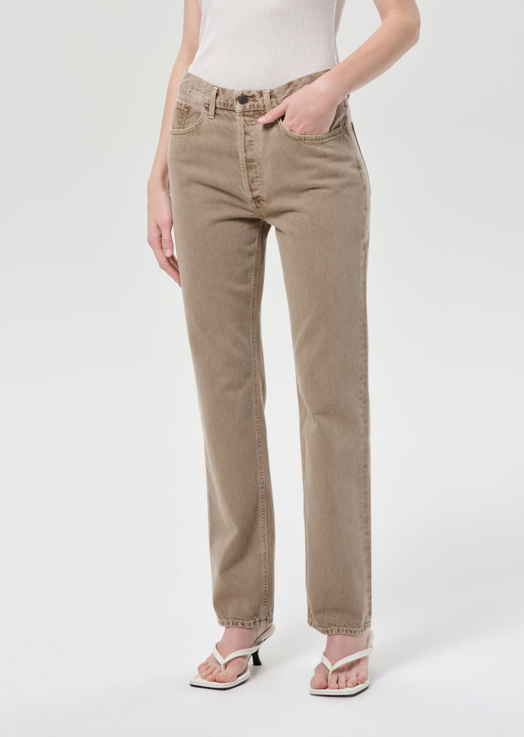 Person wearing beige pants on a white background