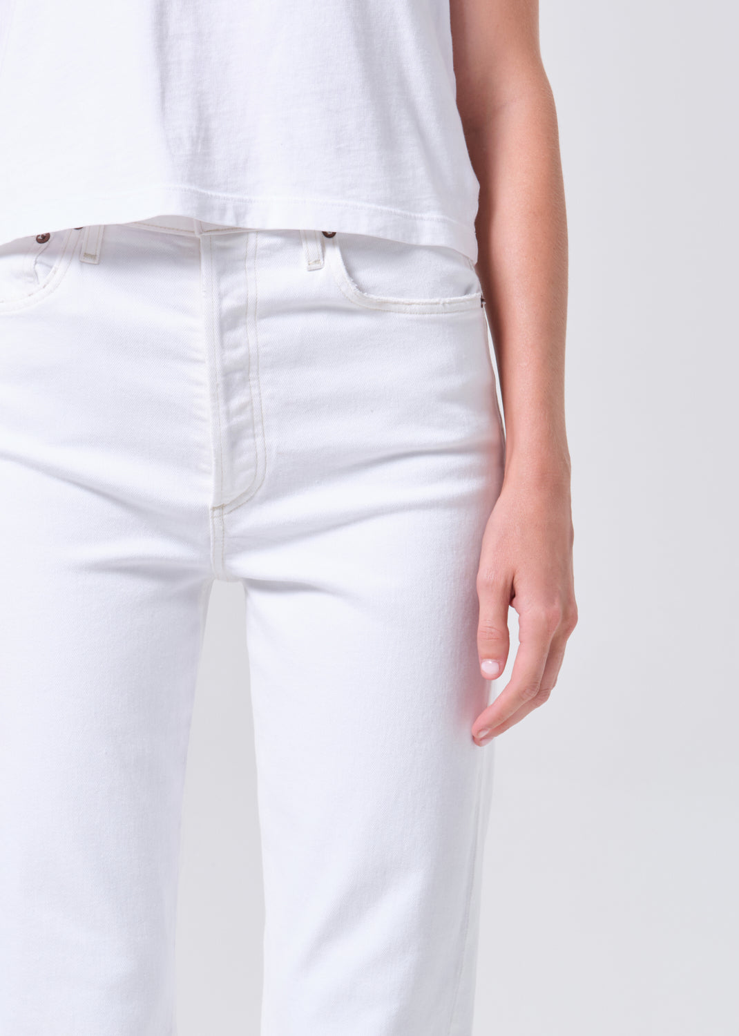 White jeans worn by a person on a white background