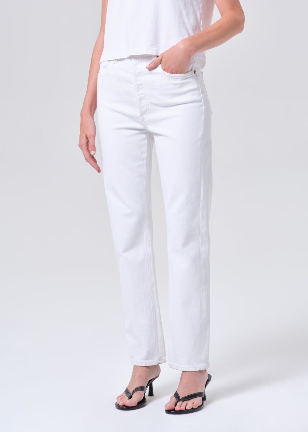 Person wearing white pants on a plain background