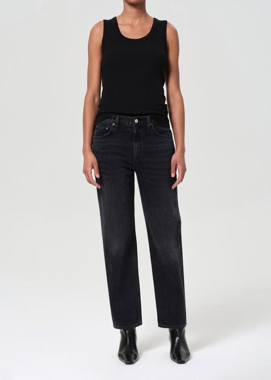 Person wearing a black tank top and black jeans on a white background