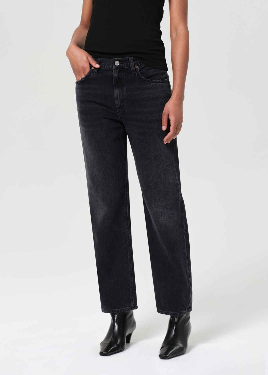 Person wearing black jeans and black top on a white background