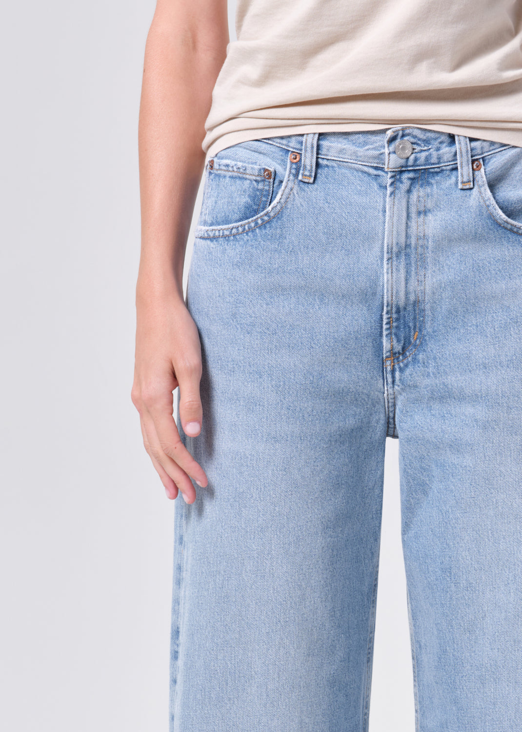 Light blue jeans worn by a person on a plain background