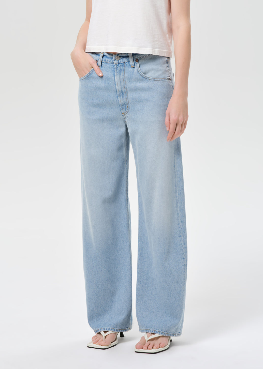Light blue jeans worn by a person on a white background